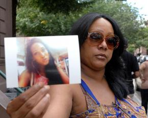 Islan's mother Dolores holds up her picture at a vigil
